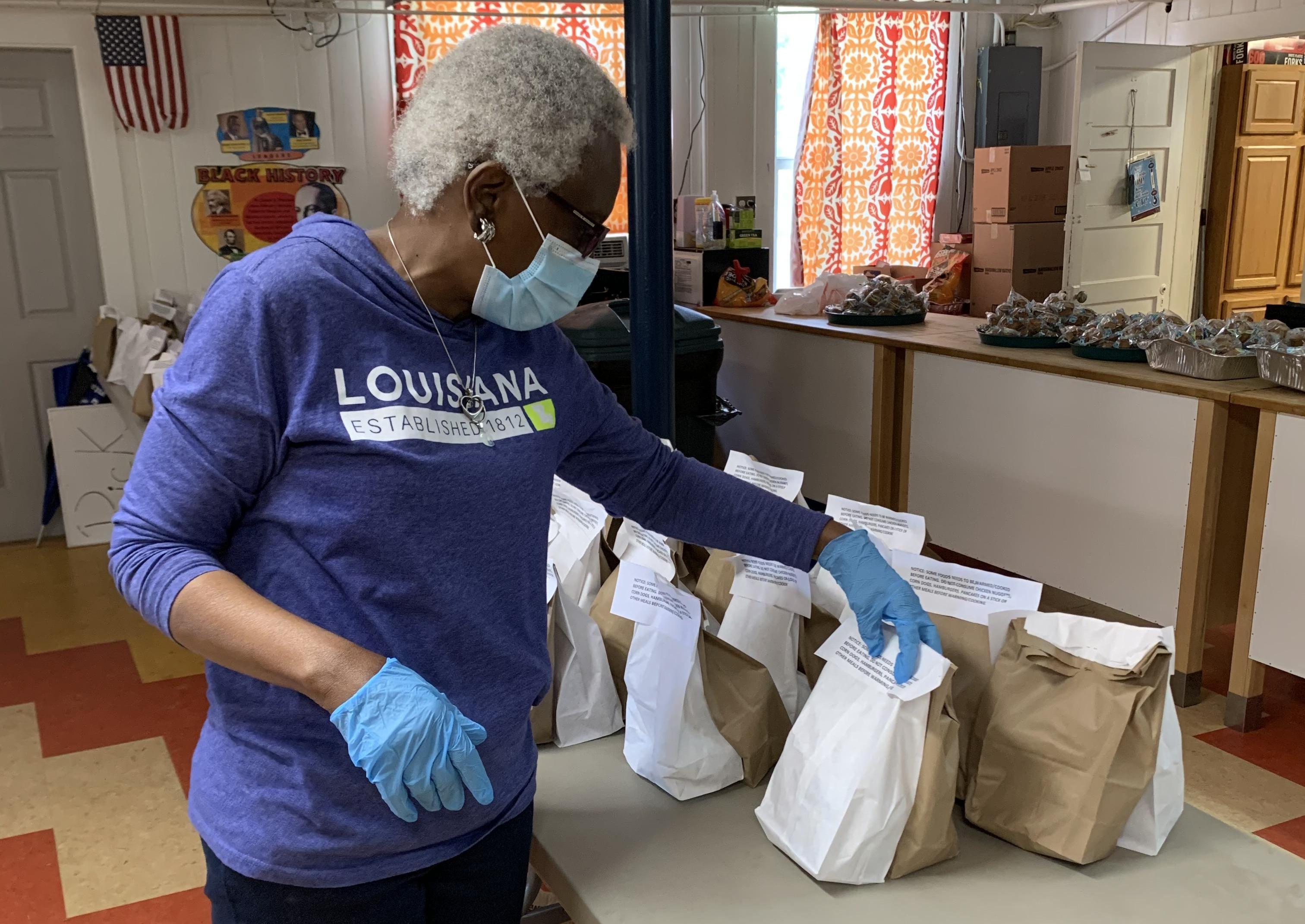 Volunteers at the Thensted Center in Grand Coteau, Louisiana, prepare sack lunches for children in the area during the COVIS-19 pandemic